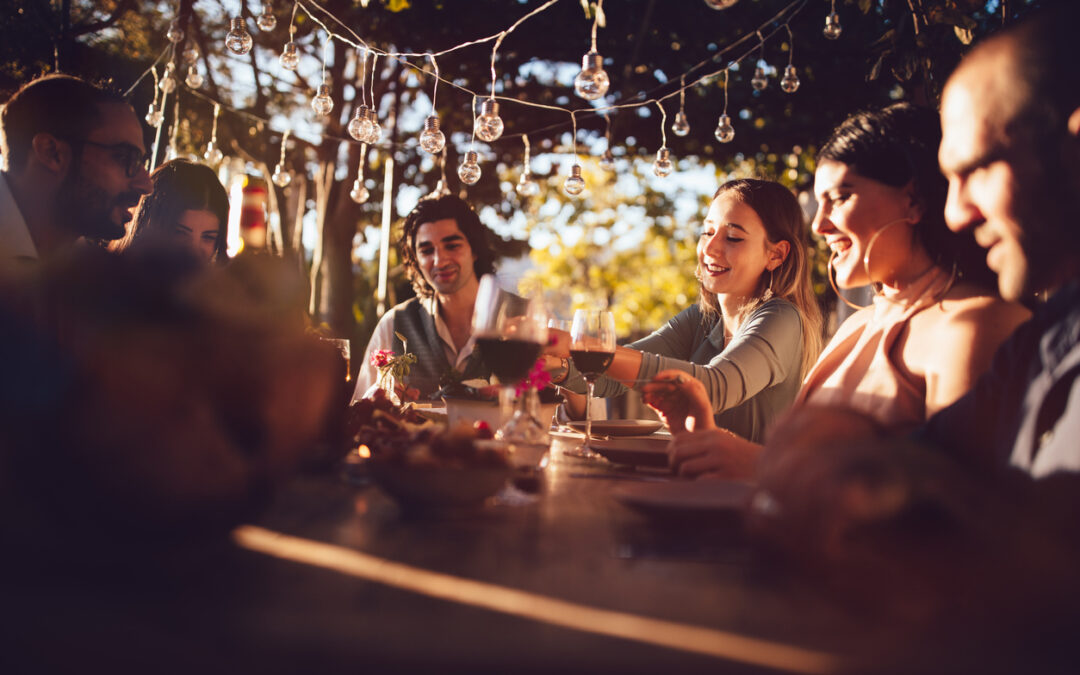 Friends celebrating with wine and food at rustic countryside party